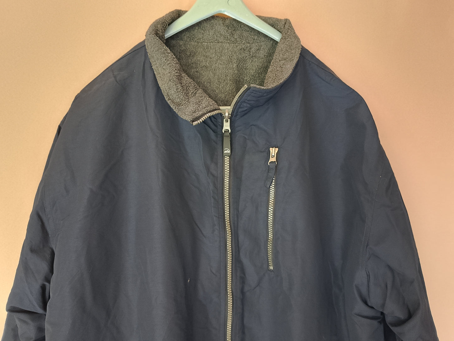 Geacă groasă, reversibilă, bleumarin cu căptușeală fleece gri.