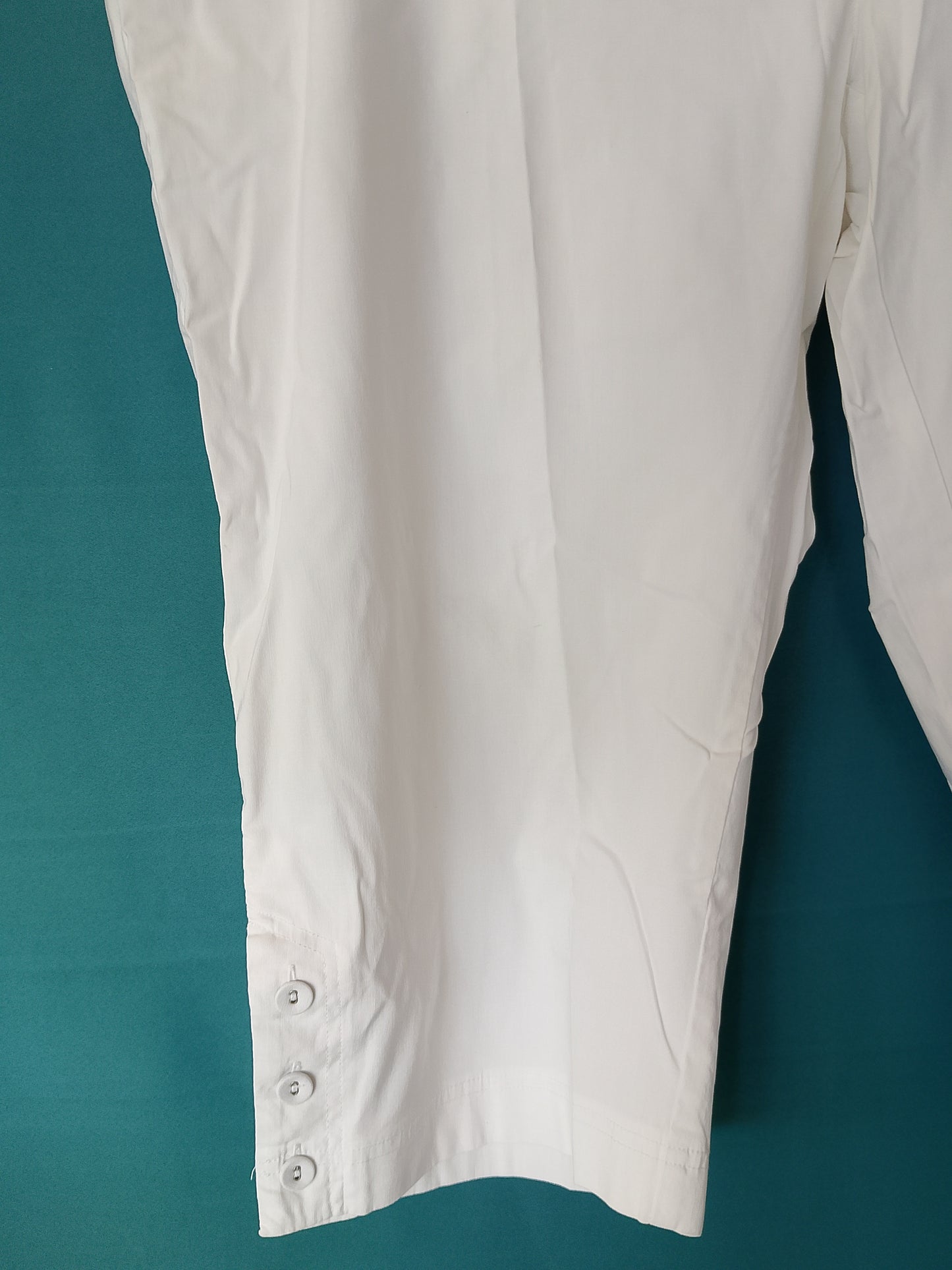 Pantaloni Capri albi, eleganți și confortabili, cu detalii discrete cu nasturi, ideali pentru vară. Marime 56.
