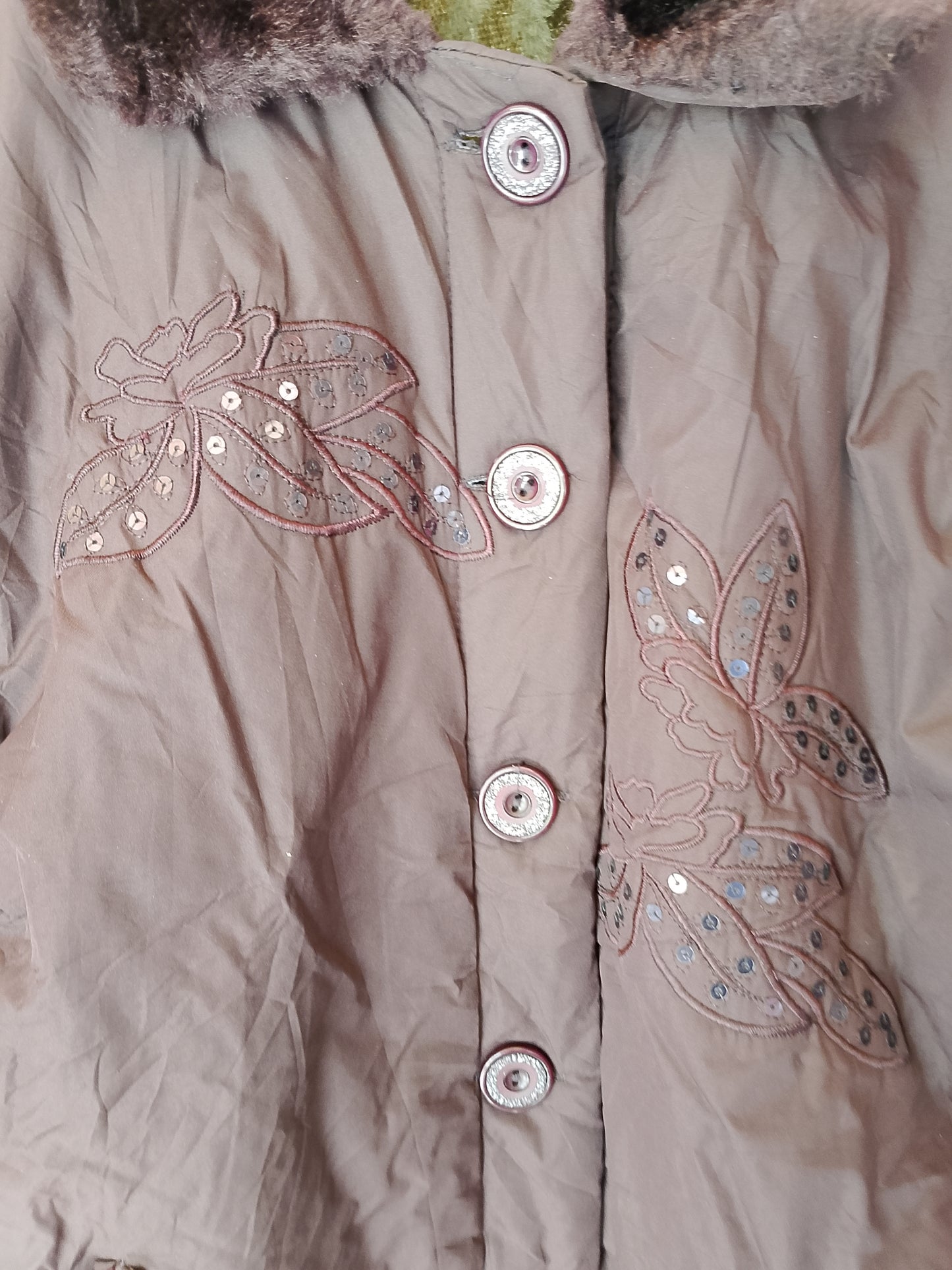 Geacă groasă, maro, cu guler din blană  și broderie, stil elegant pentru iarnă.